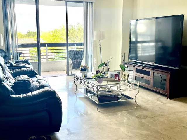 a living room with furniture and a floor to ceiling window