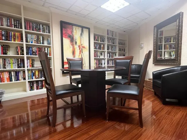 a view of a workspace with furniture window and wooden floor