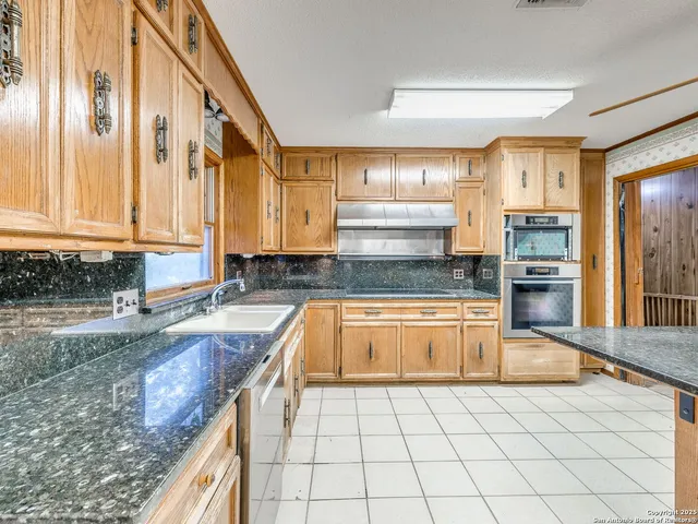 a kitchen with stainless steel appliances granite countertop a sink and cabinets