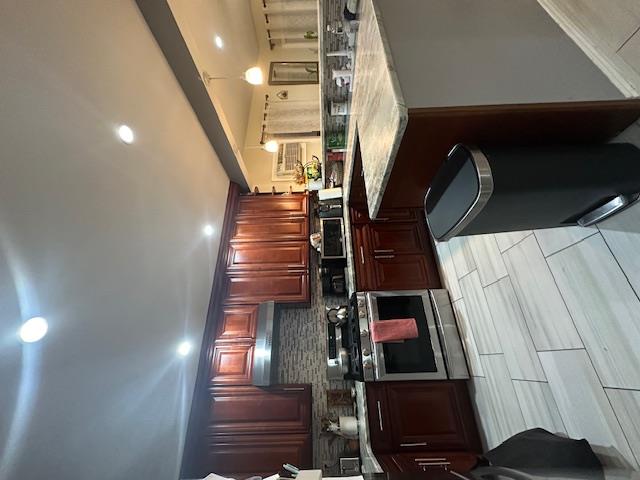 a kitchen with stainless steel appliances granite countertop wooden cabinets a stove a sink and a oven