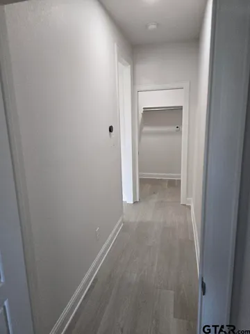 a large kitchen with kitchen island a stove a sink a refrigerator white cabinets and couches with wooden floor