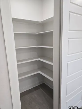 a view of walk in closet with empty racks