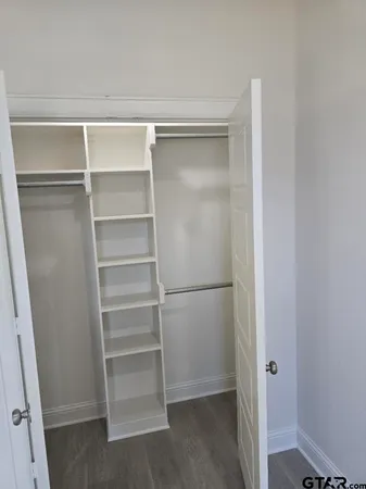 a view of walk in closet with empty racks