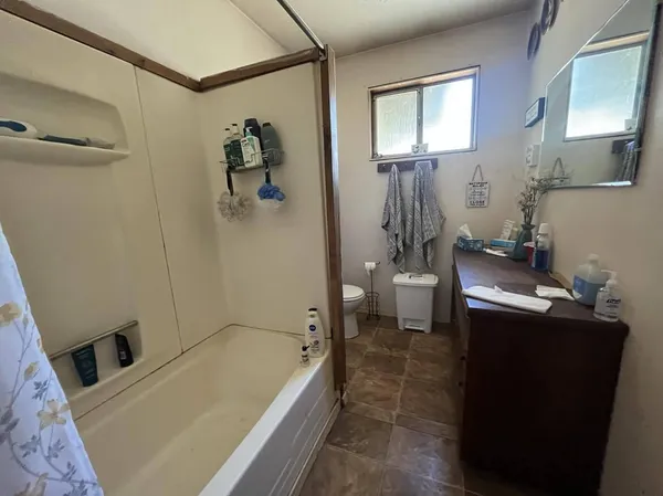 a bathroom with a granite countertop sink a toilet and shower