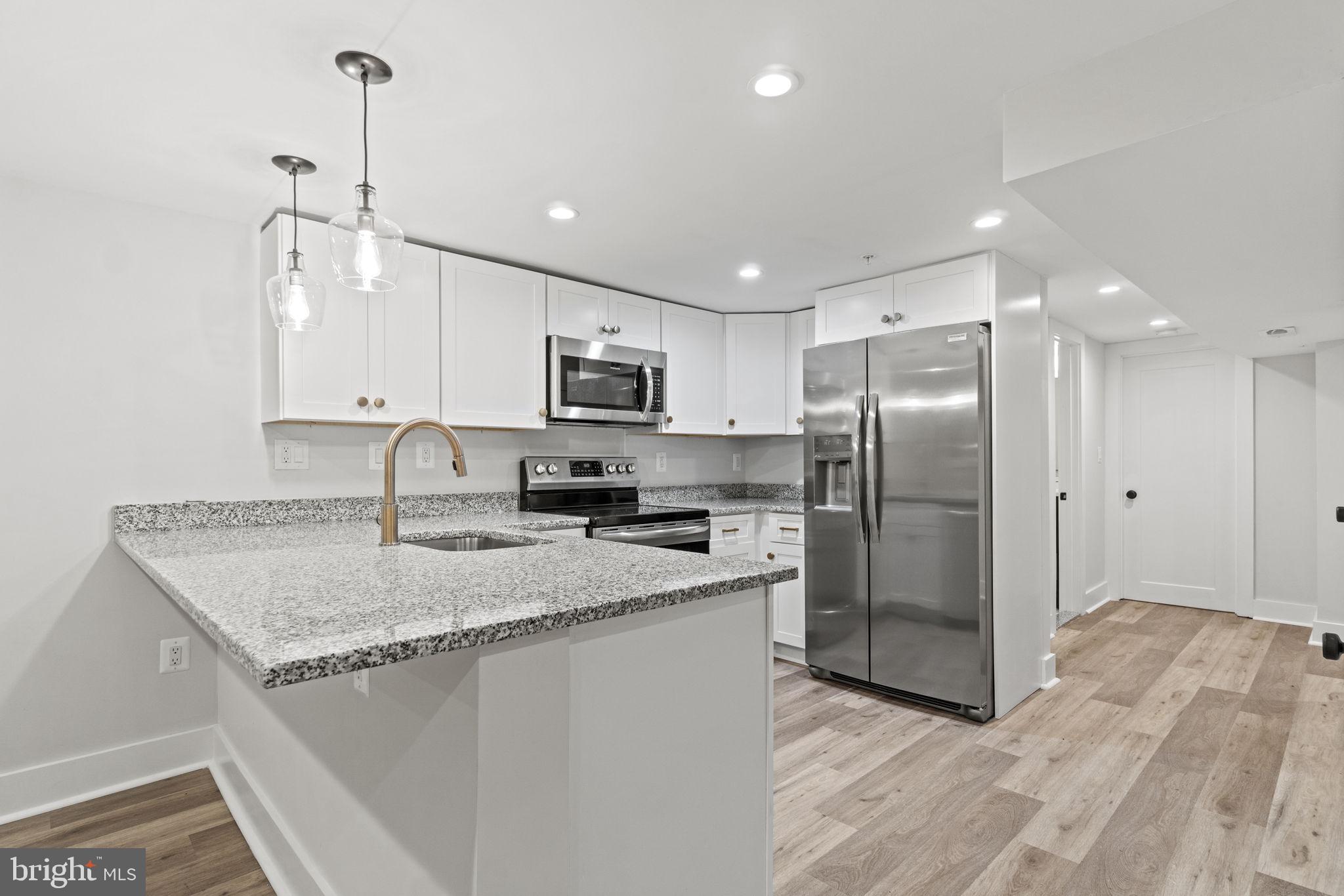 92 R Street Northwest Washington, DC 20001 - Photo 24 of 36 a kitchen with a refrigerator a sink a center island a stove and cabinets