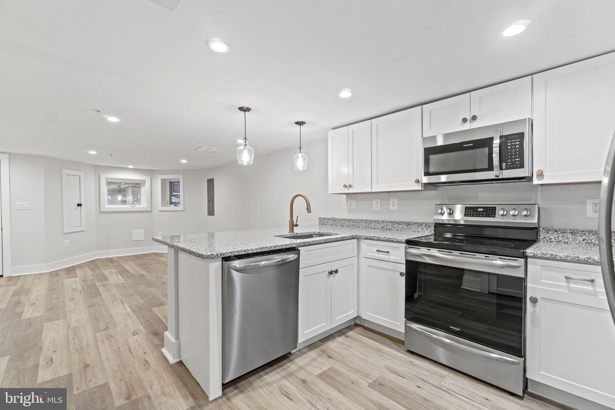 92 R Street Northwest Washington, DC 20001 - Photo 26 of 36 a kitchen with stainless steel appliances granite countertop a stove top oven a sink and white cabinets