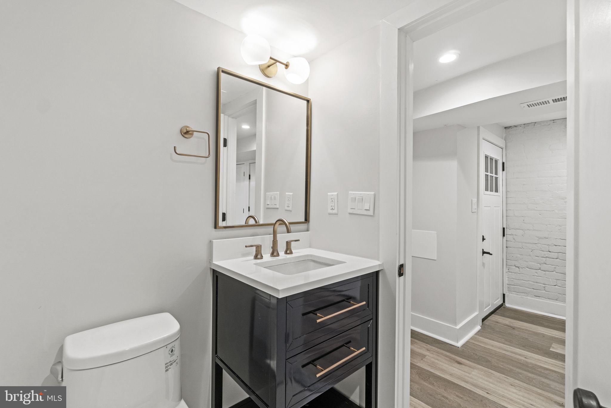 92 R Street Northwest Washington, DC 20001 - Photo 29 of 36 a bathroom with a toilet a sink a mirror and vanity