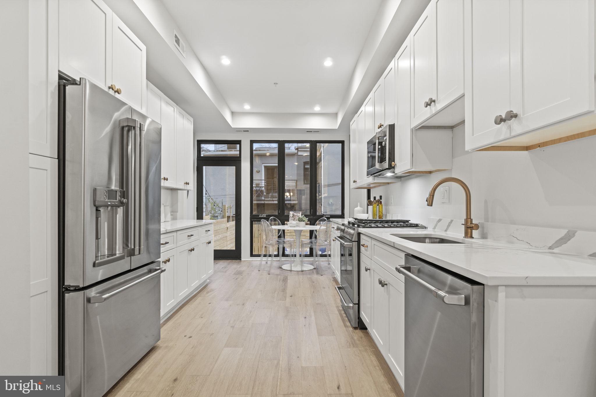 92 R Street Northwest Washington, DC 20001 - Photo 8 of 36 a kitchen with stainless steel appliances granite countertop a refrigerator a sink a stove and white cabinets