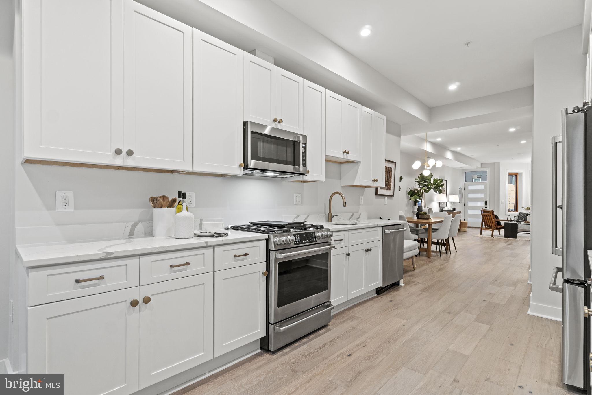 92 R Street Northwest Washington, DC 20001 - Photo 10 of 36 a kitchen with white cabinets and stainless steel appliances