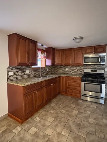 a kitchen with granite countertop a stove and cabinets