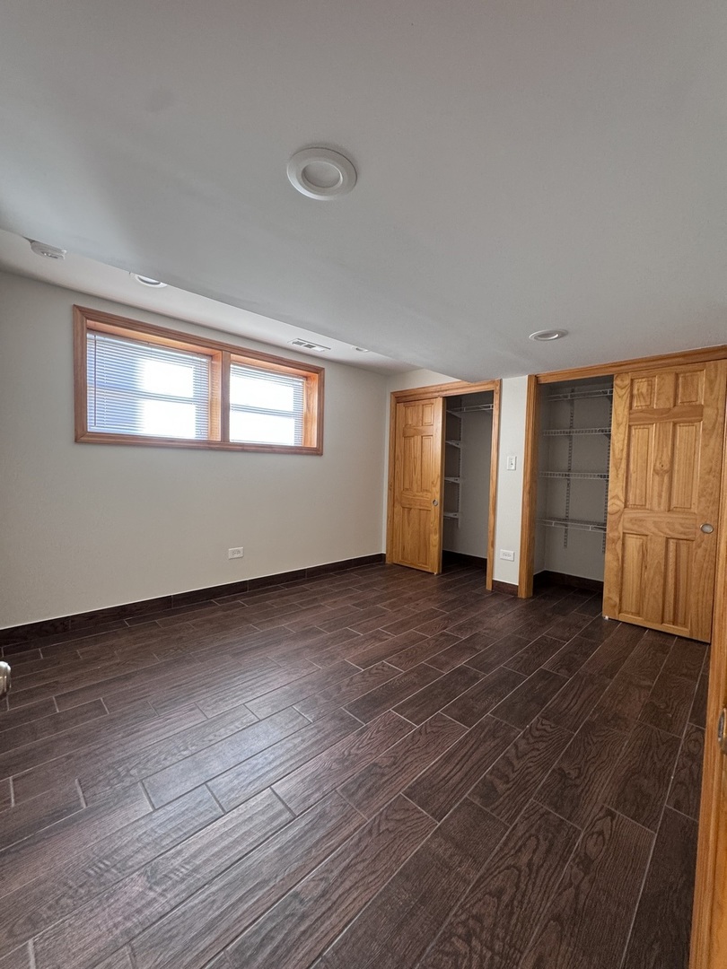 12255 South McDaniels Street, Unit GN Alsip, IL 60803 - Photo 7 of 11 a view of an empty room with wooden floor and a window