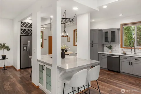 a kitchen with stainless steel appliances granite countertop a refrigerator a sink a stove and a refrigerator