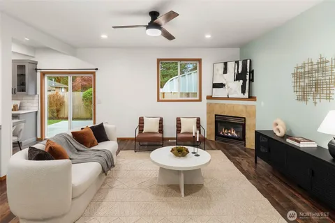 a living room with furniture a rug a fireplace and a window