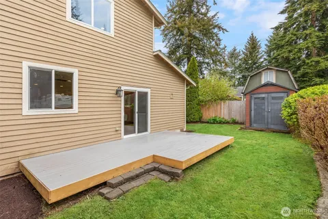 a view of an house with backyard and a tree
