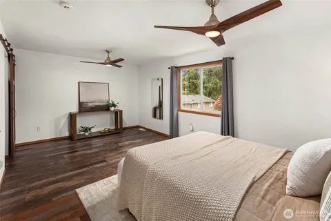 a bedroom with a bed and a flat tv screen on a dresser