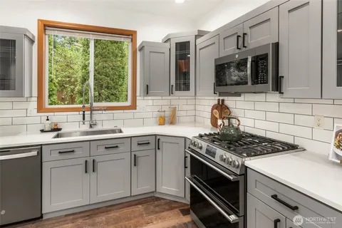 a kitchen with stainless steel appliances a stove sink and microwave
