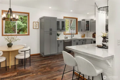 a kitchen with a table chairs refrigerator and microwave