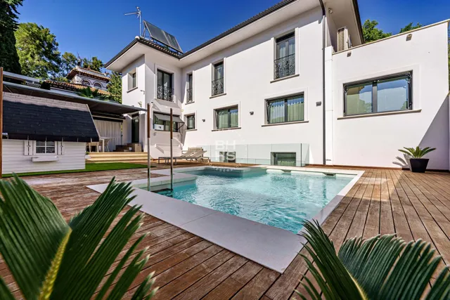 a view of a house with pool and chairs