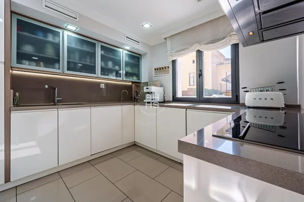 a kitchen with stainless steel appliances kitchen island granite countertop a sink and white cabinets