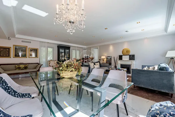 a living room with furniture a chandelier and a dining table