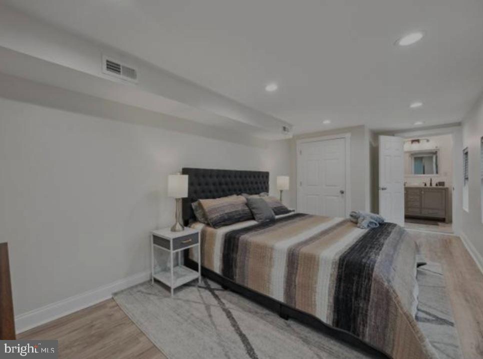 401 South Ann Street Baltimore, MD 21231 - Photo 4 of 30 a bedroom with a bed and a lamp