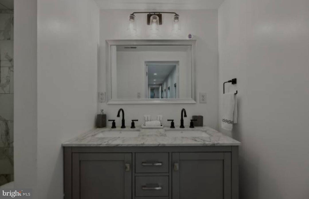 401 South Ann Street Baltimore, MD 21231 - Photo 9 of 30 a bathroom with a granite countertop sink a toilet and a mirror