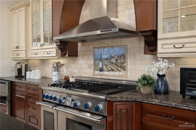 a kitchen with kitchen island granite countertop a stove and a sink