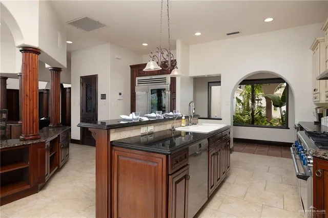 a kitchen with stove a sink and cabinets