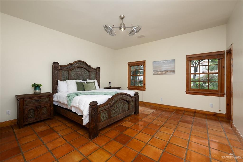 3506 Oak Ridge Lane Mission, TX 78573 - Photo 26 of 45 a bed sitting in a bedroom next to a window with a chandelier