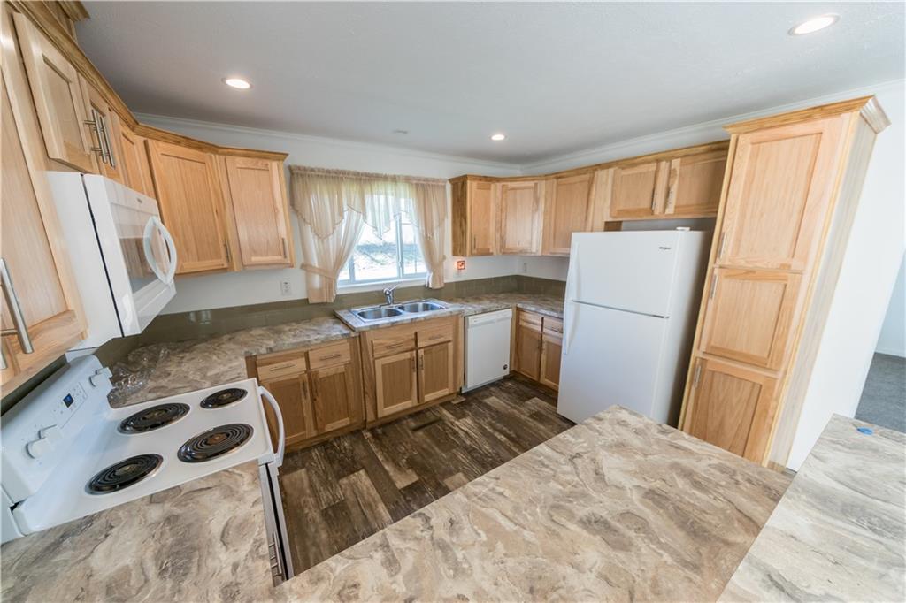 910 Jefferson Road Waynesburg, PA 15370 - Photo 6 of 17 a kitchen with a refrigerator a stove a sink dishwasher and wooden cabinets with wooden floor