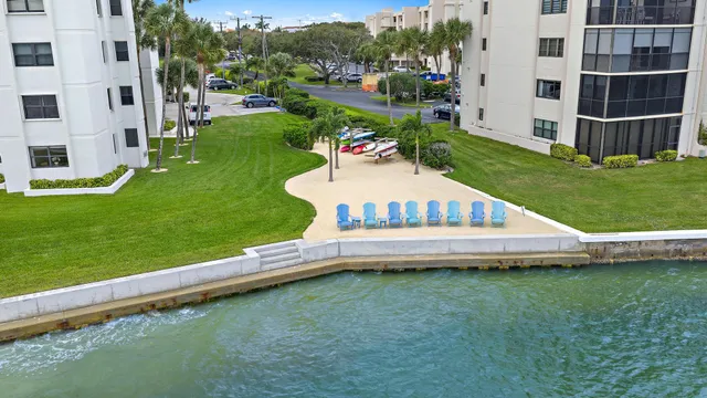 an aerial view of lake and residential houses with outdoor space and swimming pool
