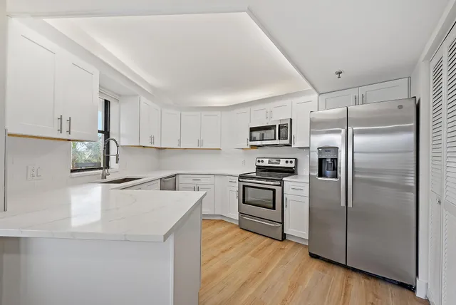 a kitchen with a sink stove top oven and cabinets