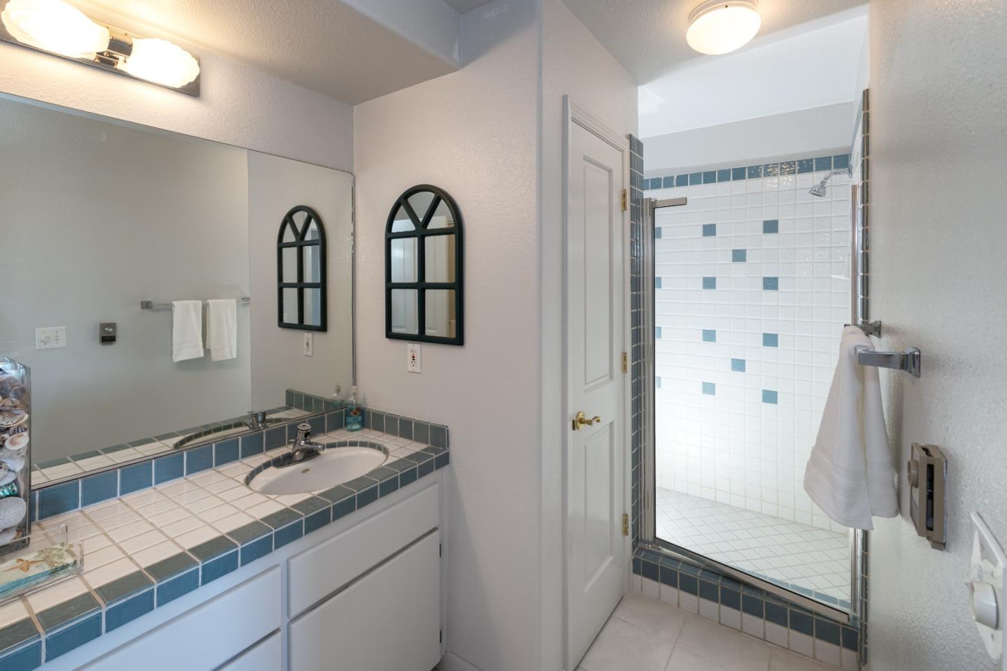 202 Seacliff Drive Aptos, CA 95003 - Photo 21 of 36 a bathroom with a granite countertop sink a mirror and shower