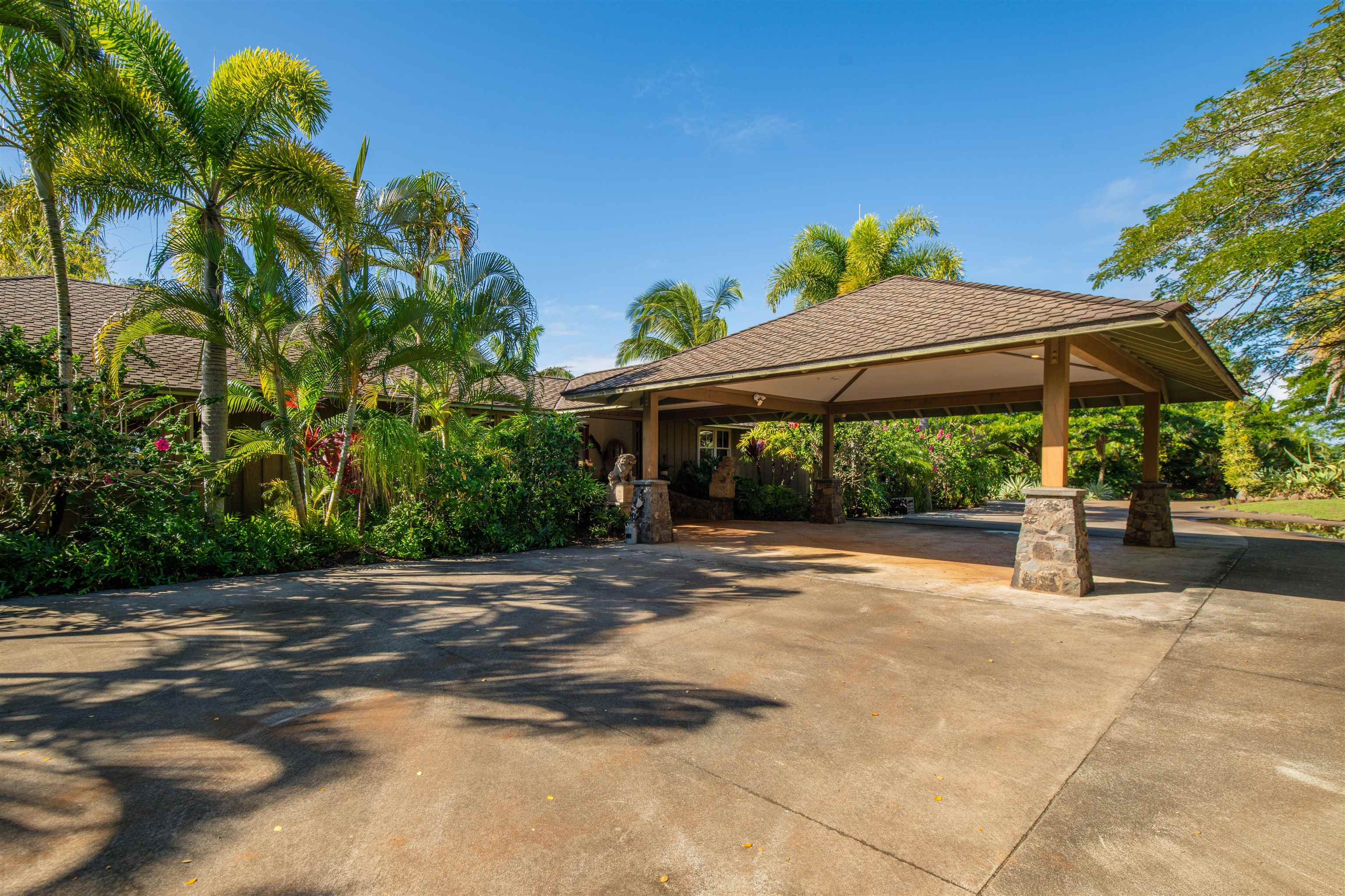 52 Papio Way, Unit A Haiku, HI 96708 - Photo 50 of 50 a backyard of a house with table and chairs under an umbrella