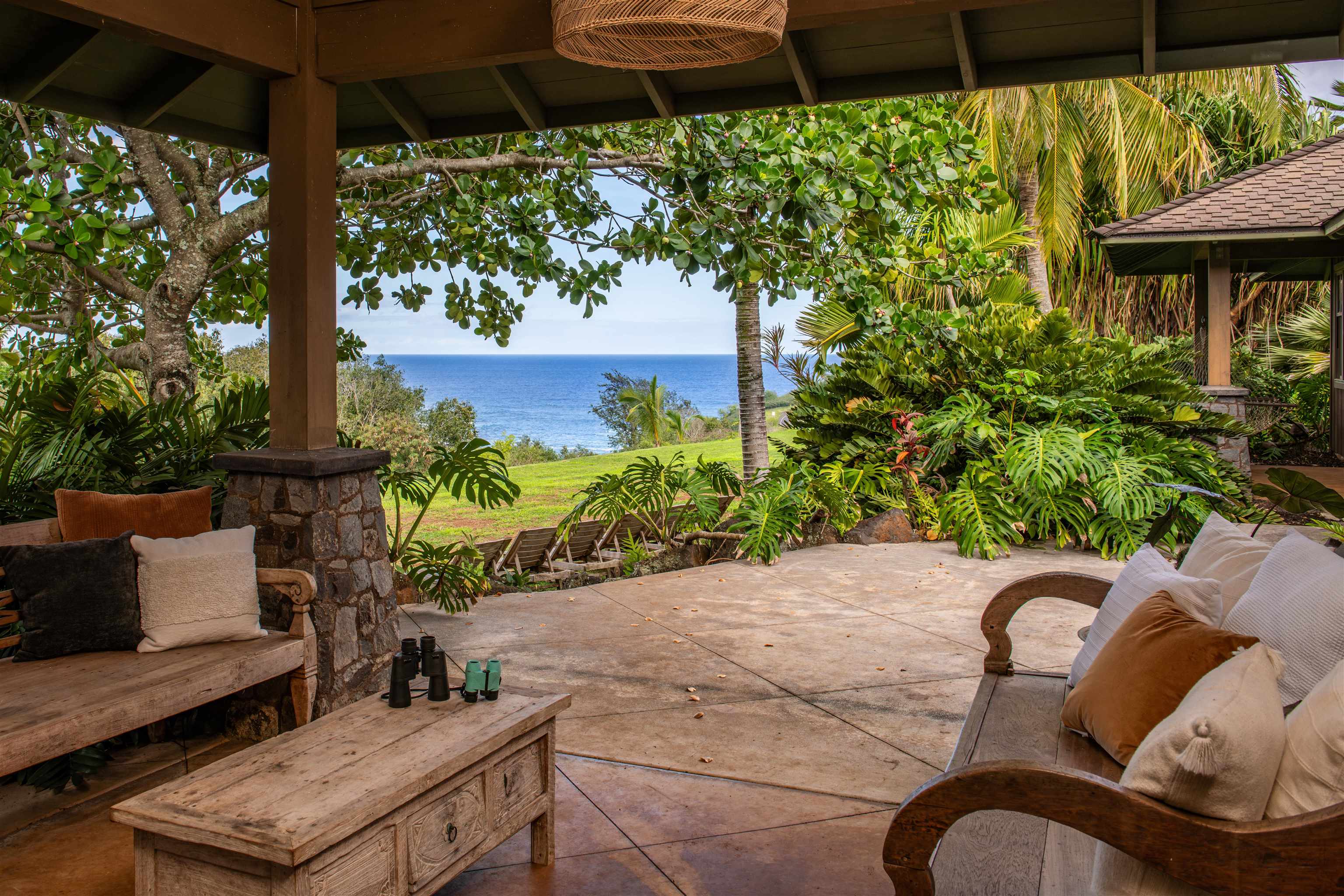 52 Papio Way, Unit A Haiku, HI 96708 - Photo 5 of 50 a backyard of a house with table and chairs potted plants