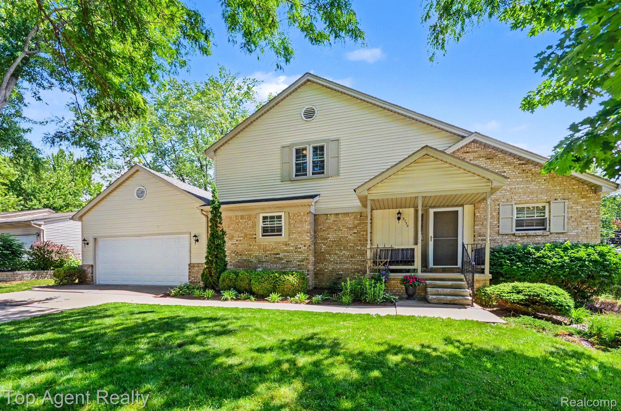 3759 Donley Avenue Rochester, MI 48309 - Photo 26 of 29 Exterior featuring a covered porch with concrete steps, stone and siding facade, and a two-car garage with an overhead door