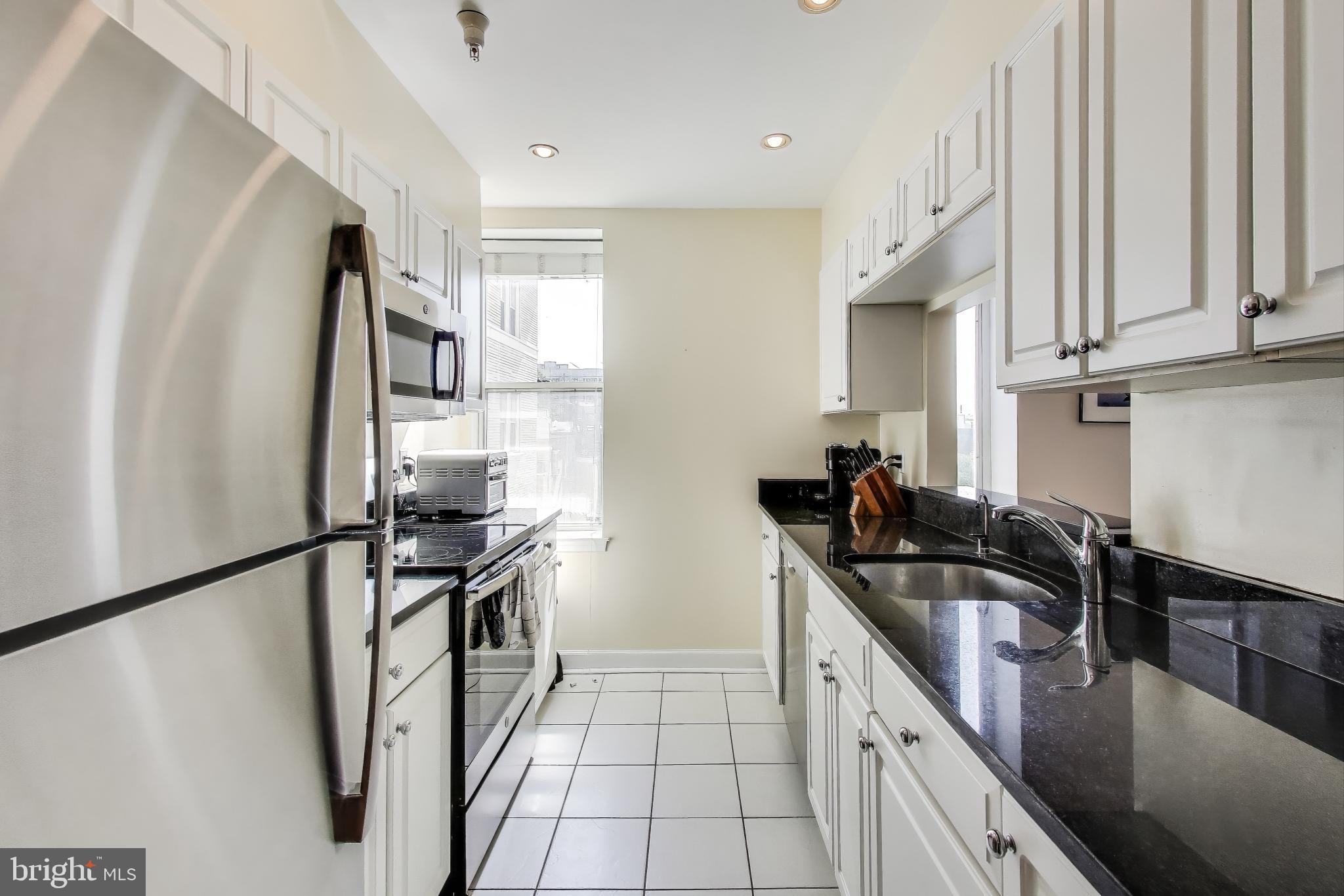1619 R Street Northwest, Unit 501 Washington, DC 20009 - Photo 13 of 25 a kitchen with granite countertop a sink appliances and cabinets