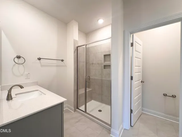 a bathroom with a shower sink and mirror