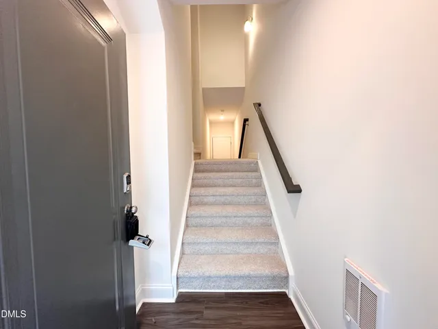 a view of a hallway with wooden floor and entryway