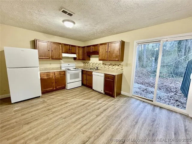 a kitchen with stainless steel appliances granite countertop a refrigerator a stove a sink dishwasher and a refrigerator