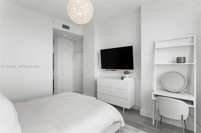 a bedroom with a bed and a flat screen tv