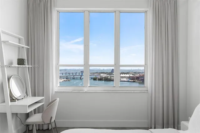 a view of a room that has a window and chair