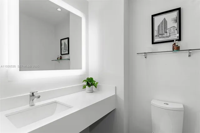 a bathroom with a sink a toilet and mirror