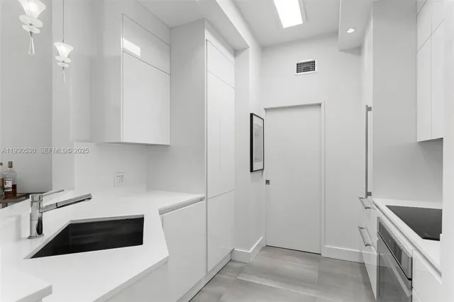 a kitchen with a refrigerator and white cabinets