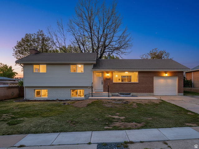 2068 West 5950th Street South Roy, UT 84067 - Photo 1 of 1 Split level home featuring a garage, a front lawn, driveway, a porch, and a chimney