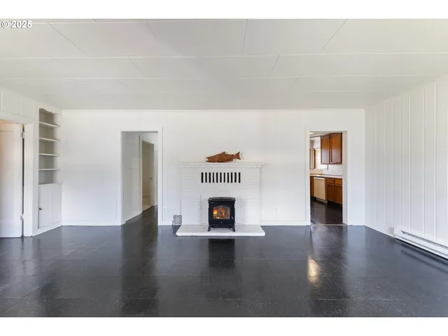 a view of a living room with wooden floors and fireplace