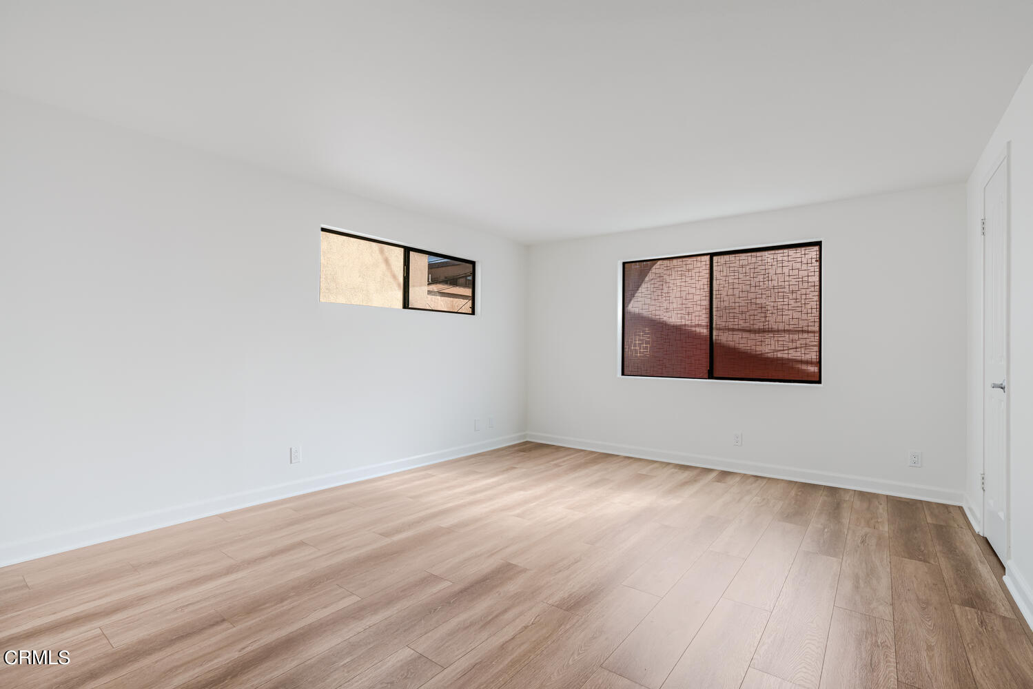 312 Melrose Drive Oxnard, CA 93035 - Photo 28 of 58 an empty room with wooden floor and windows