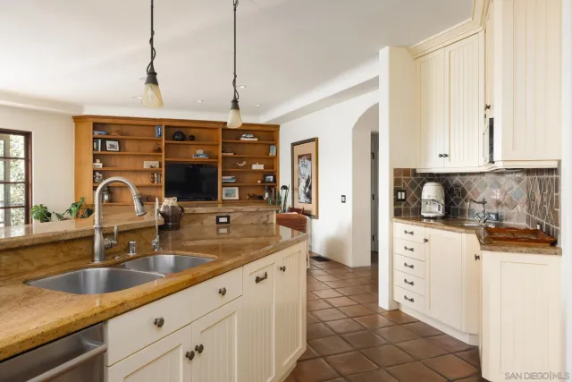 a kitchen with stainless steel appliances granite countertop a sink and white cabinets