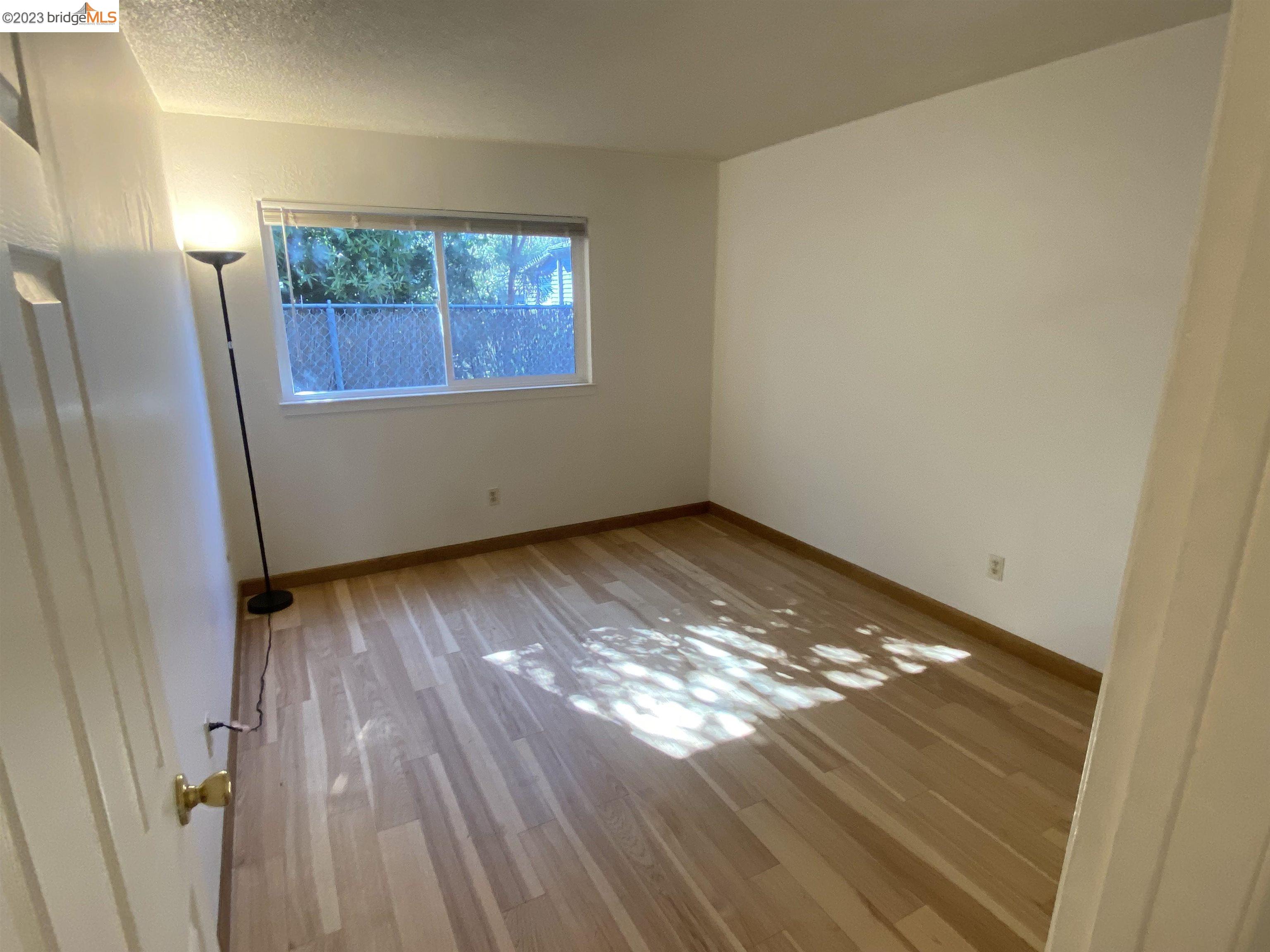 968 45th Street, Unit A Oakland, CA 94608 - Photo 14 of 16 a view of an empty room with wooden floor and a window