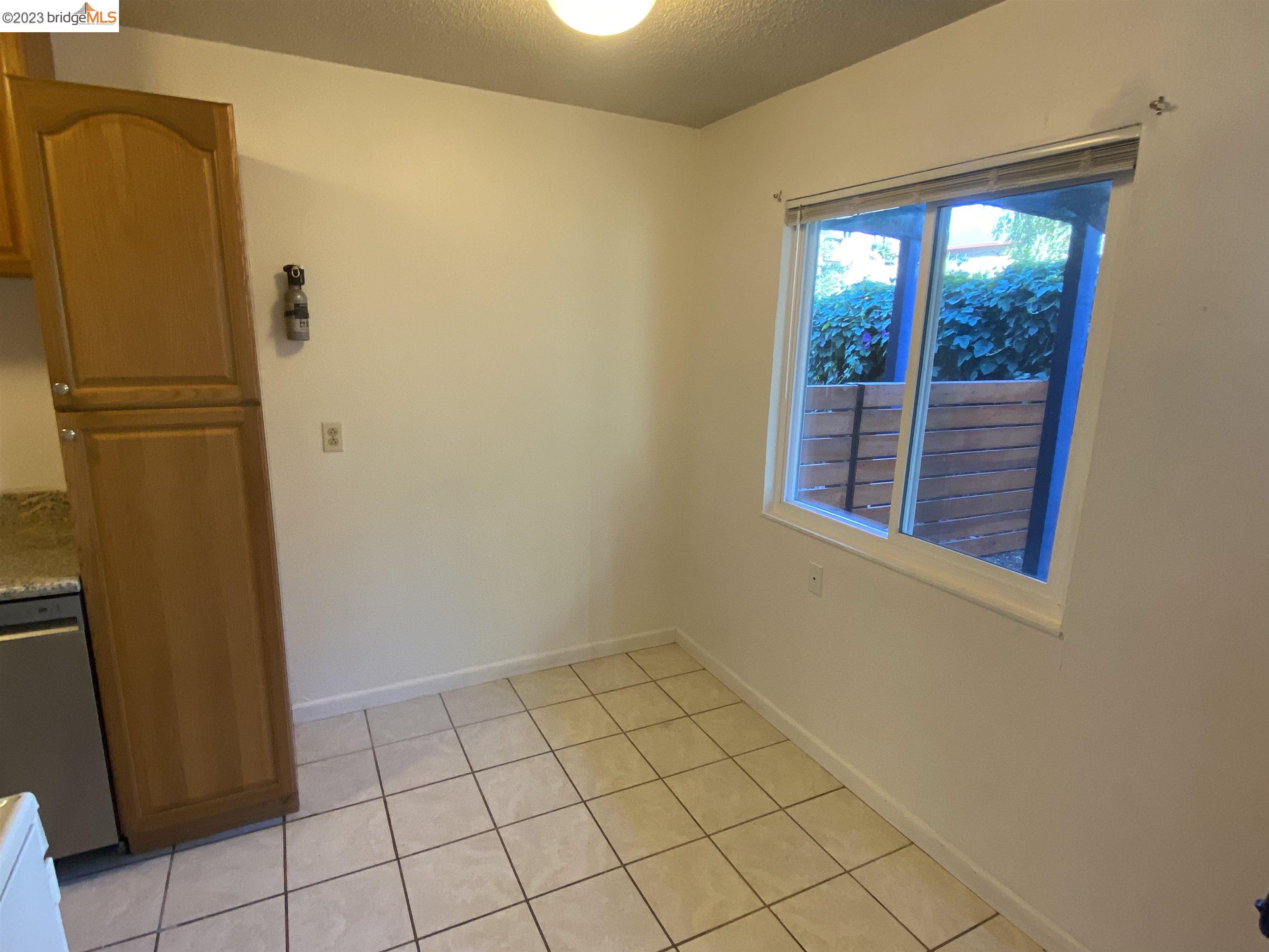 968 45th Street, Unit A Oakland, CA 94608 - Photo 5 of 16 a view of a refrigerator in kitchen and a window